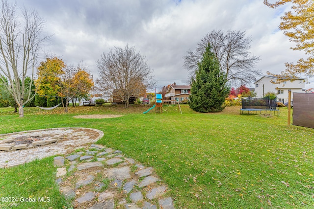 view of yard with a playground and a trampoline