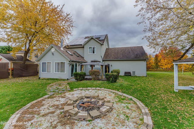 back of house featuring a gazebo, a yard, and a fire pit