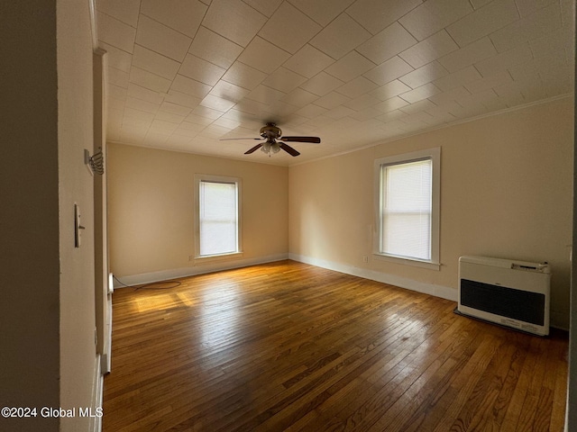 interior space with crown molding, wood-type flooring, heating unit, and ceiling fan