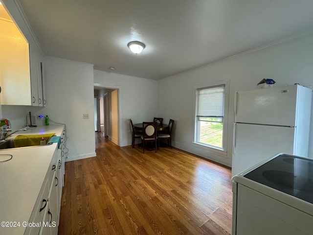 kitchen featuring electric range oven, light hardwood / wood-style flooring, crown molding, white cabinetry, and white fridge