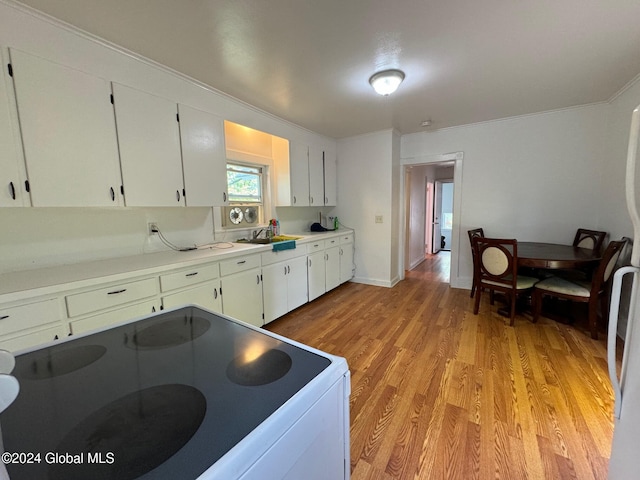 kitchen featuring white cabinetry, light hardwood / wood-style flooring, range, crown molding, and sink