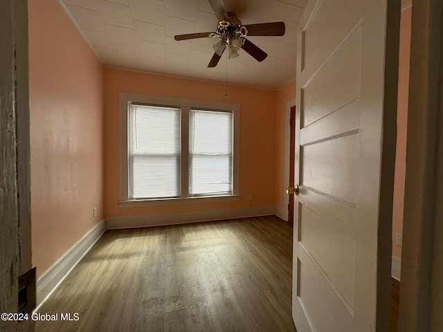 spare room featuring crown molding, light wood-type flooring, and ceiling fan