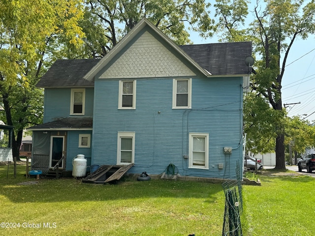 rear view of property with a yard