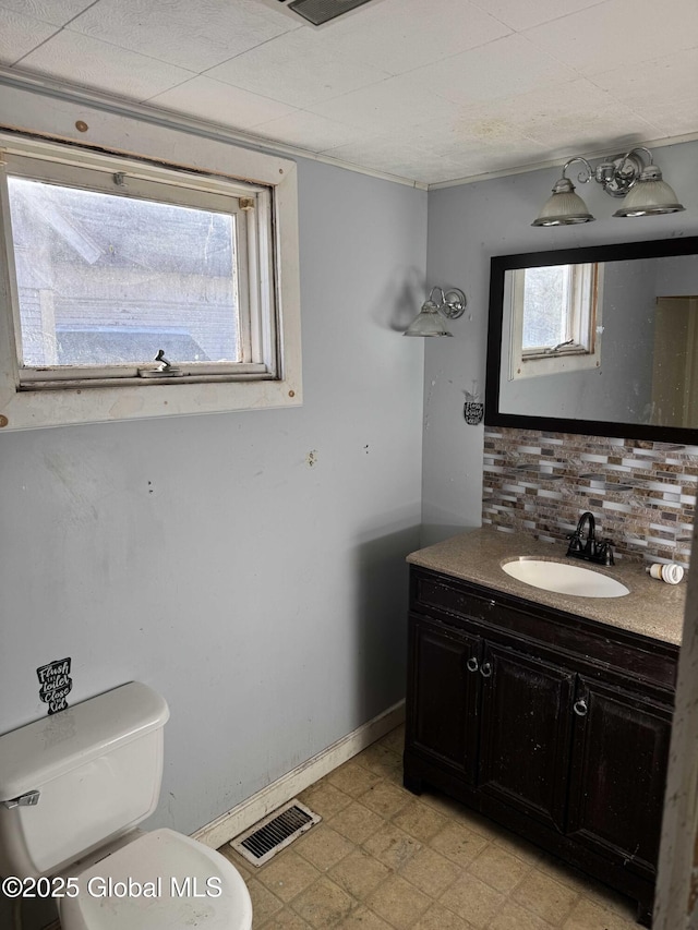 bathroom featuring tasteful backsplash, vanity, and toilet