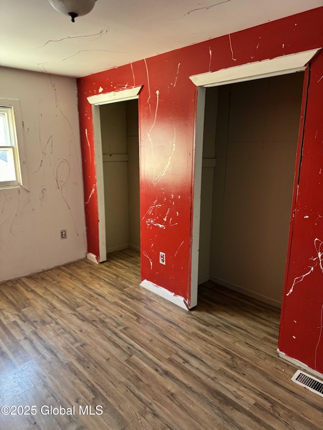 unfurnished bedroom featuring dark hardwood / wood-style flooring and a closet