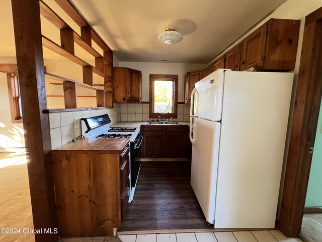 66 Plains Rd, Jackson, NY 12816 - kitchen featuring brown cabinetry, freestanding refrigerator, tasteful backsplash, a sink, and gas stove