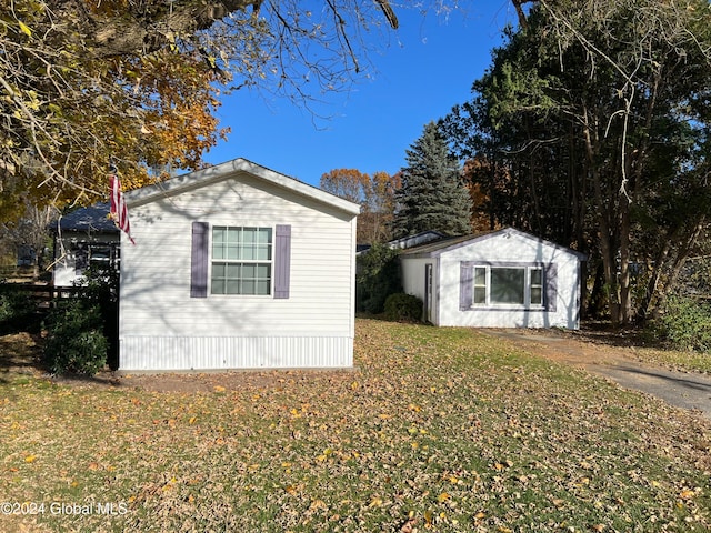 view of property exterior with a storage shed and a lawn