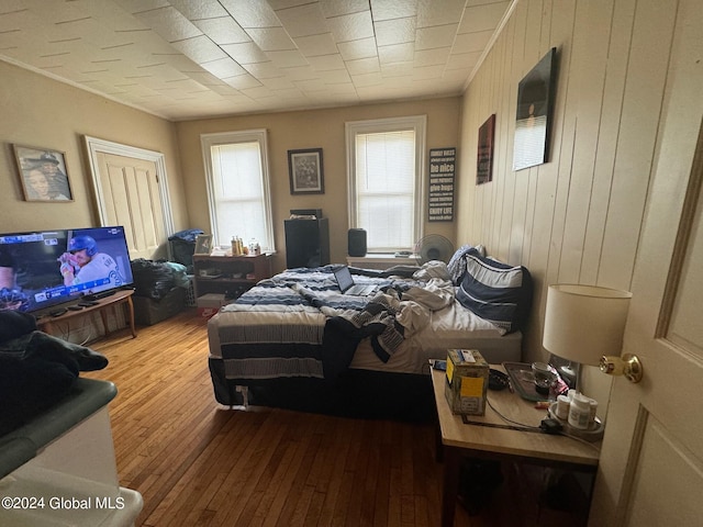 bedroom featuring hardwood / wood-style floors and wooden walls