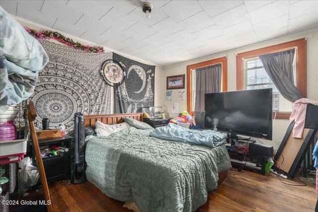 bedroom featuring ornamental molding and dark hardwood / wood-style floors