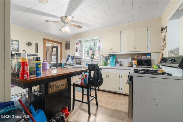 kitchen with white cabinets, ceiling fan, white electric range oven, and crown molding