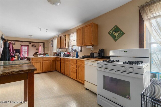 kitchen with kitchen peninsula, sink, and white appliances