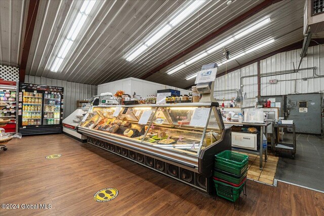 interior space with wood walls, wood-type flooring, and vaulted ceiling