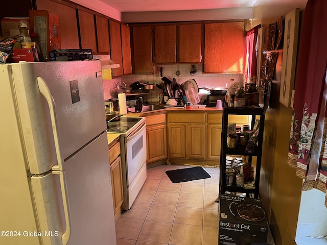 kitchen featuring white range with electric cooktop, stainless steel fridge, light tile patterned floors, tasteful backsplash, and custom range hood