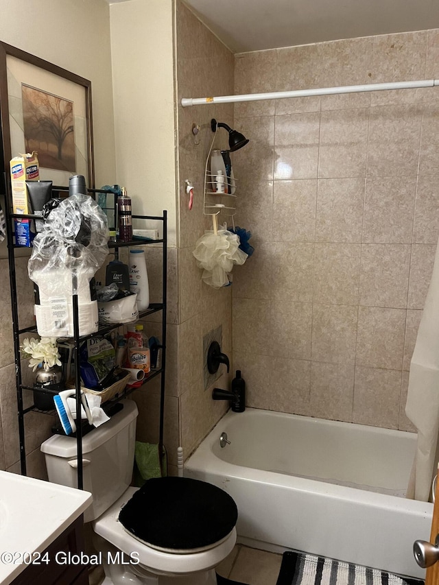 full bathroom featuring tiled shower / bath, vanity, and toilet