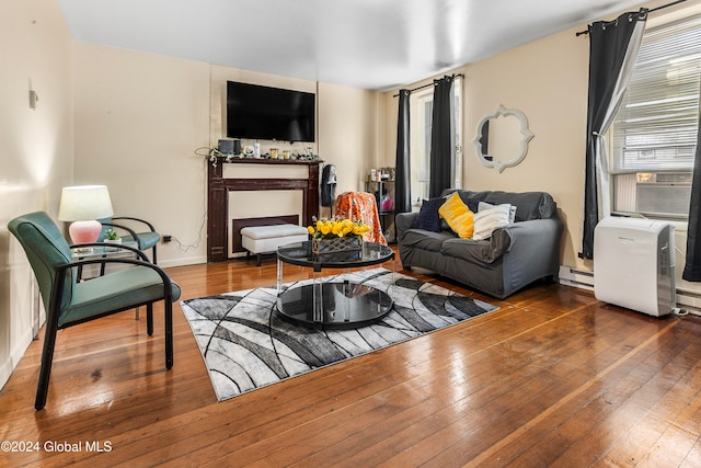 living room featuring wood-type flooring, cooling unit, and baseboard heating