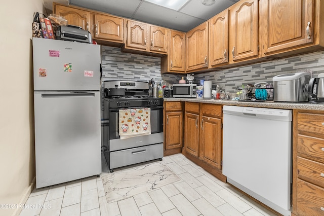 kitchen with a drop ceiling, stainless steel appliances, and tasteful backsplash