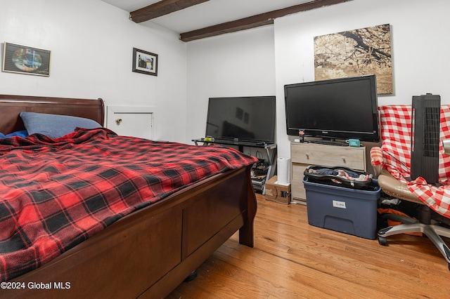 bedroom with beam ceiling and light hardwood / wood-style flooring