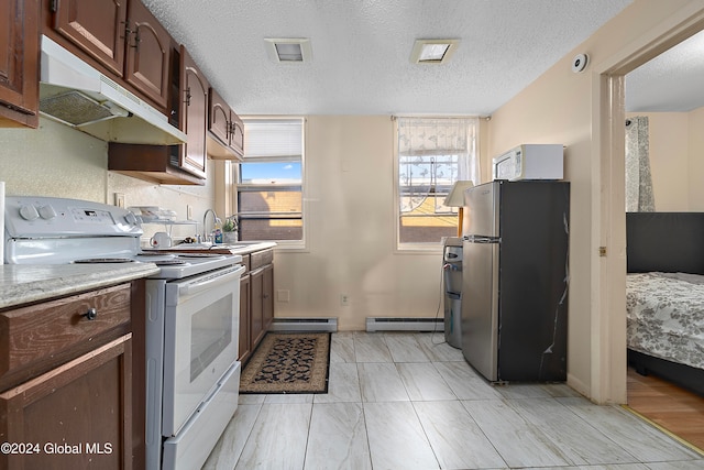 kitchen featuring a baseboard radiator, sink, a textured ceiling, and white appliances