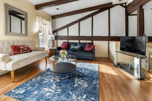 living room featuring beamed ceiling and hardwood / wood-style floors