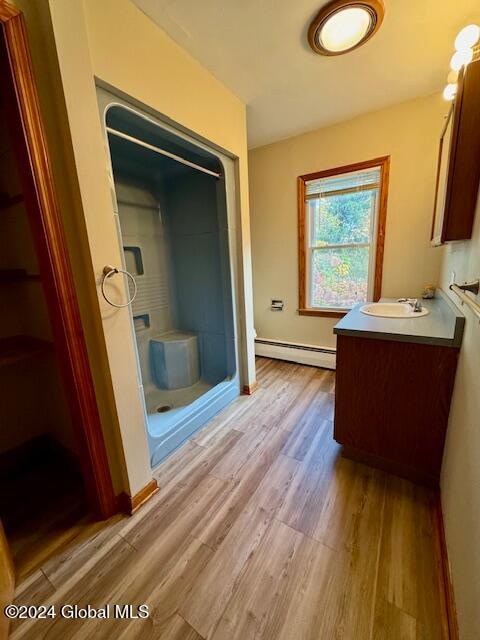 bathroom with vanity, wood-type flooring, and a baseboard radiator