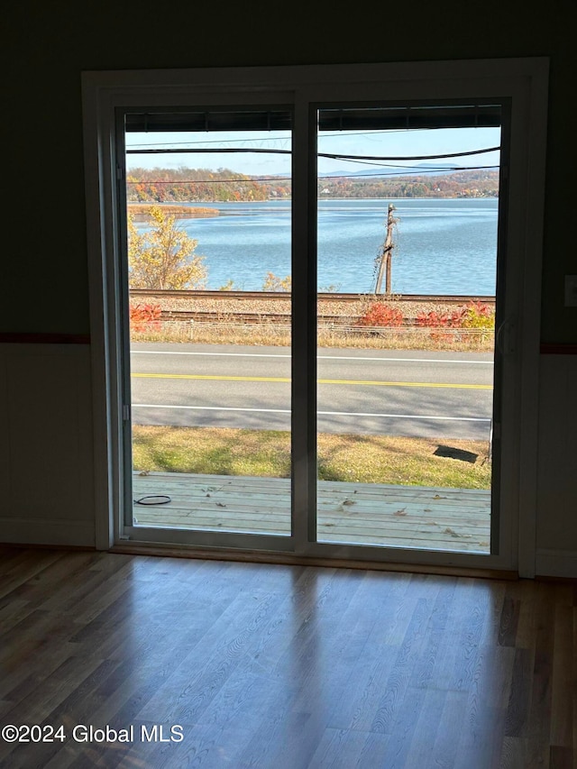 doorway to outside with hardwood / wood-style floors, a water view, and a healthy amount of sunlight