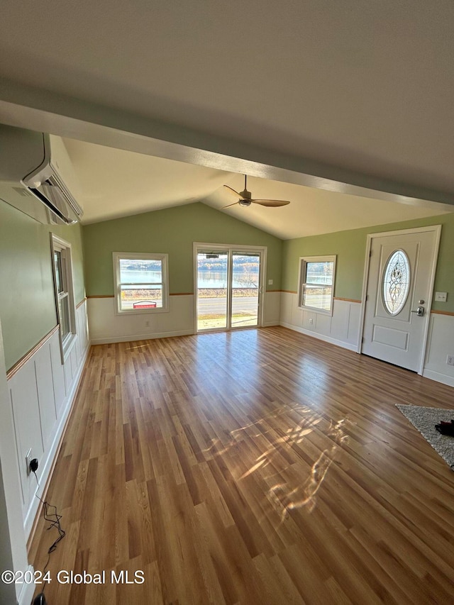 unfurnished living room featuring lofted ceiling, hardwood / wood-style floors, and ceiling fan