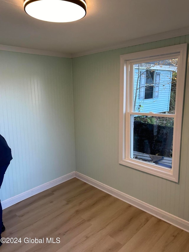 unfurnished room featuring ornamental molding and hardwood / wood-style floors