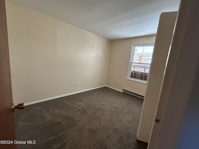 carpeted empty room featuring baseboard heating