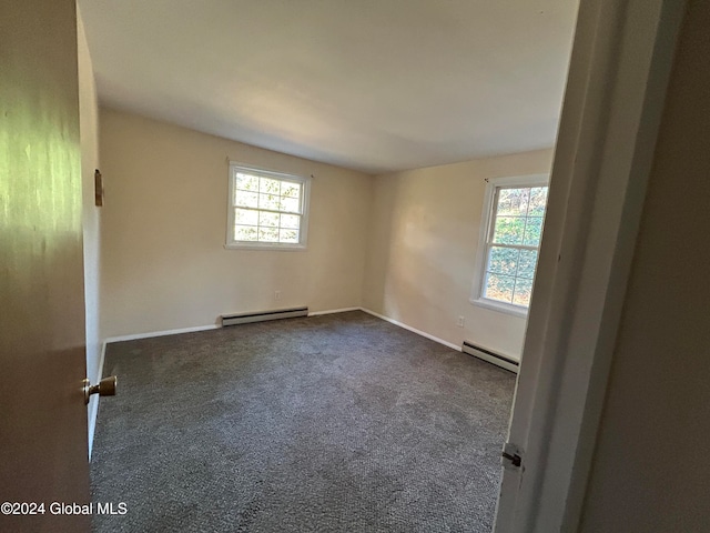 carpeted empty room with a wealth of natural light and baseboard heating