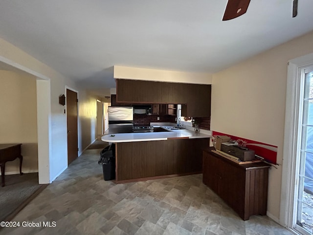 kitchen with sink, dark brown cabinets, kitchen peninsula, ceiling fan, and stainless steel appliances