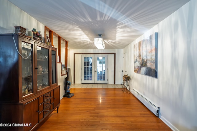 interior space featuring french doors, light hardwood / wood-style flooring, and a baseboard radiator