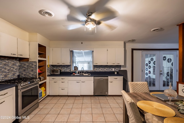 kitchen with appliances with stainless steel finishes, tasteful backsplash, white cabinetry, and french doors