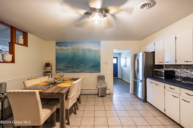 kitchen with decorative backsplash, white cabinetry, stainless steel appliances, and light tile patterned floors