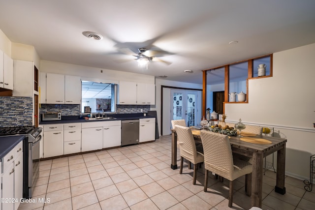 kitchen with appliances with stainless steel finishes, tasteful backsplash, ceiling fan, sink, and white cabinets