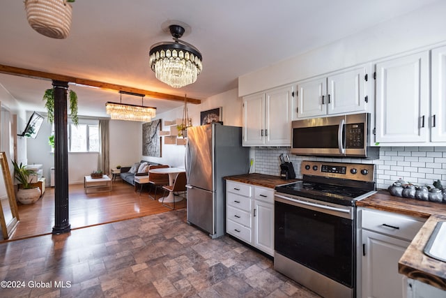 kitchen with white cabinets, pendant lighting, butcher block counters, and stainless steel appliances