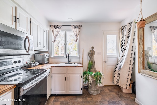 kitchen featuring white cabinets, stainless steel appliances, tasteful backsplash, and sink