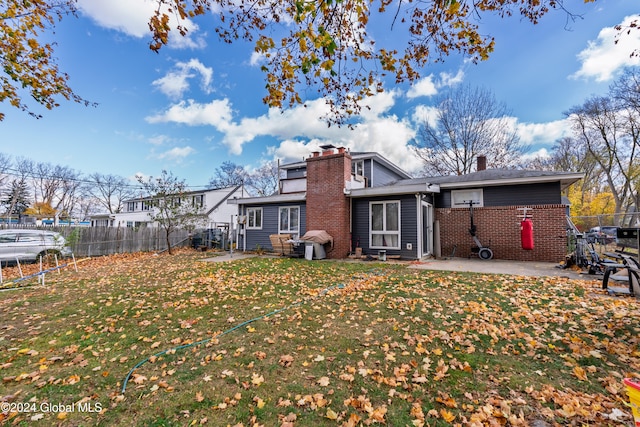 rear view of property featuring a lawn and a patio