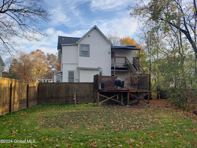 rear view of property featuring a wooden deck and a yard