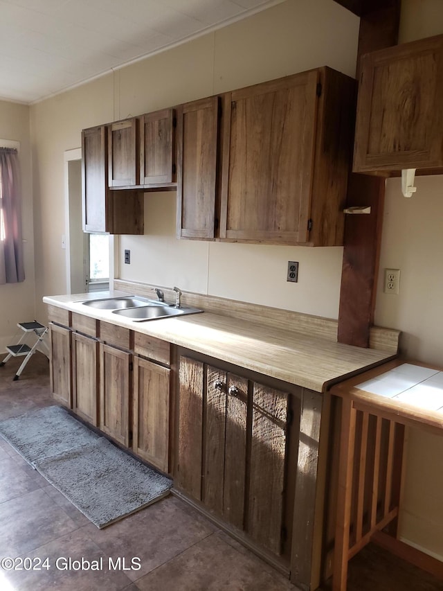 kitchen featuring light tile patterned floors and sink