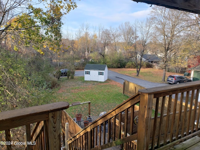 deck featuring a shed and a lawn