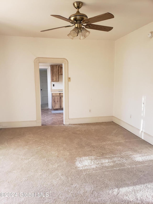 carpeted empty room featuring ceiling fan