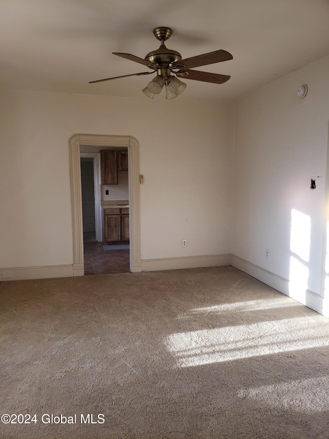 carpeted spare room featuring ceiling fan