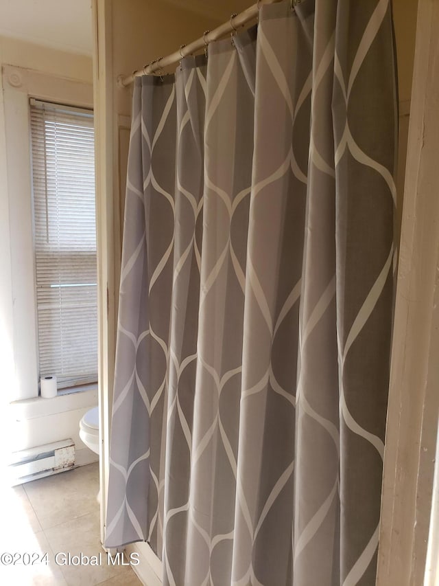 bathroom with toilet, a baseboard heating unit, tile patterned flooring, and a shower with shower curtain