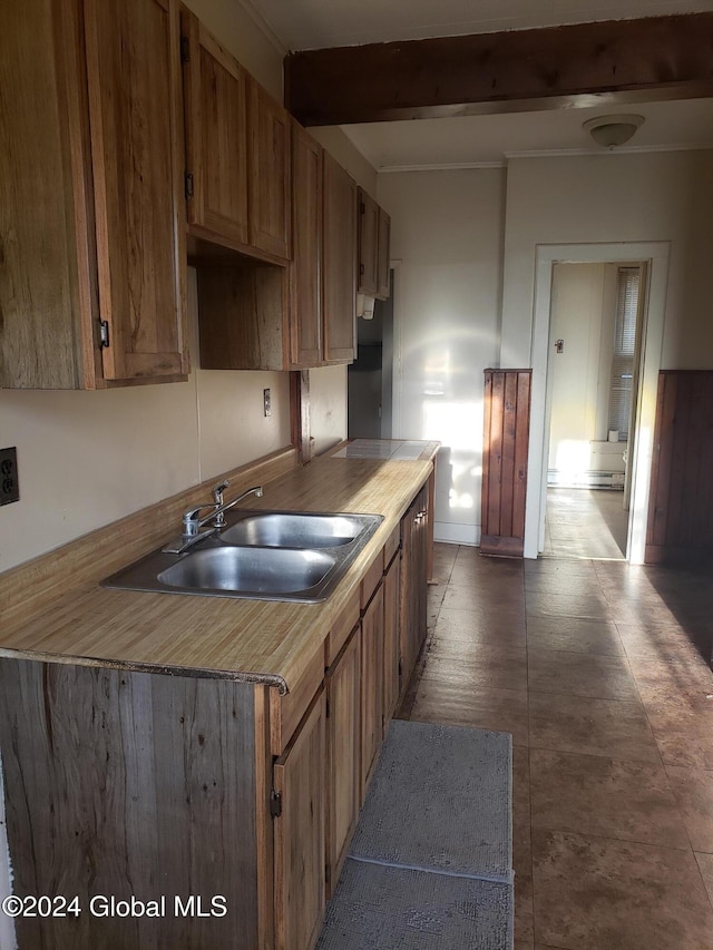 kitchen featuring beam ceiling and sink