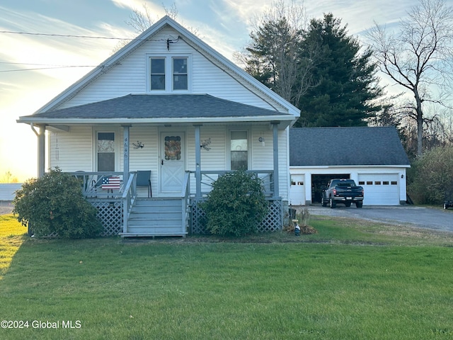 view of front of property featuring a porch, a garage, and a lawn