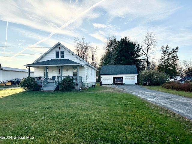 view of front facade with an outbuilding, a garage, a front lawn, and a porch