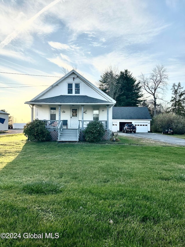 view of front of home with a garage, a lawn, and covered porch