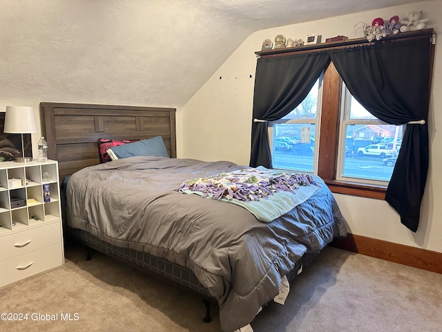 bedroom with lofted ceiling, light colored carpet, and a textured ceiling