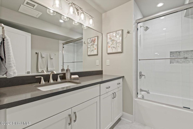 bathroom featuring tile patterned flooring, vanity, and bath / shower combo with glass door