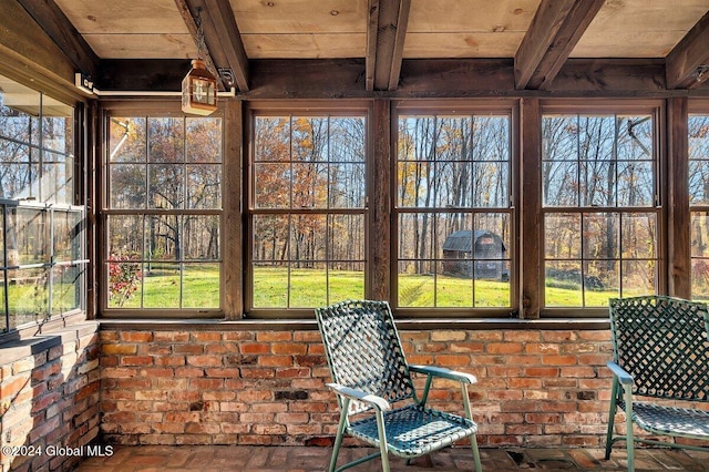 unfurnished sunroom with wood ceiling, beam ceiling, and a wealth of natural light